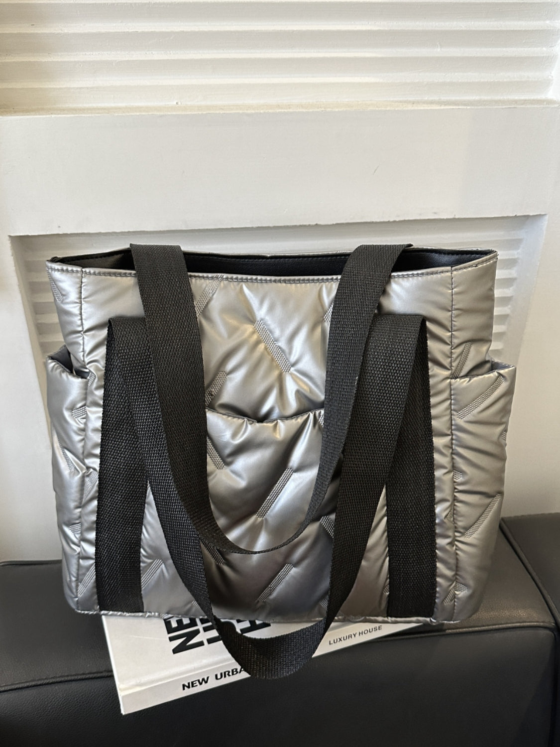 Large solid color tote bag with side pockets, made of polyester, featuring black straps and a stylish padded design.